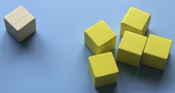 Vários cubos sendo um grupo amarelo e um cubo em cor de madeira, representando as classes ANBIMA